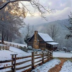 a log cabin in the snow with trees and fence around it, surrounded by mountains