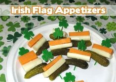 a plate with pickles, carrots and cheese on it next to shamrock leaves