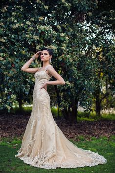 a woman in a wedding dress posing for the camera with her hand on her head