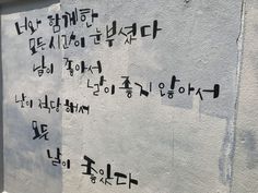 some writing on the side of a building in korean characters are written with black ink