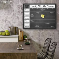 a family weekly planner on a chalkboard in a dining room with two chairs and a table