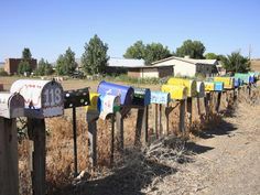 several mail boxes are lined up along the fence