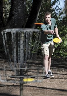 a man is throwing frisbees in the park