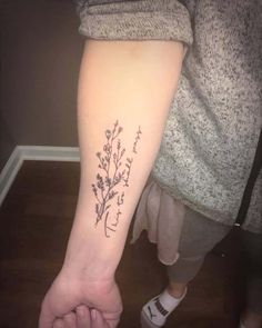 a person with a tattoo on their arm holding the hand of another person's foot