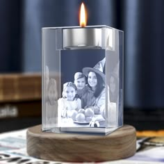 a candle that is sitting on top of a wooden stand with a photo in it