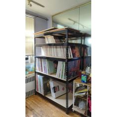 a book shelf filled with lots of books on top of a hard wood floor