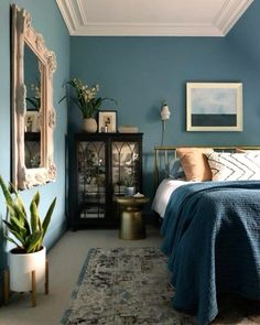 a bed room with a neatly made bed and blue walls