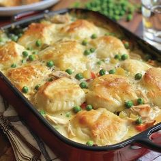 a casserole dish with peas, chicken and dumplings in it on a table