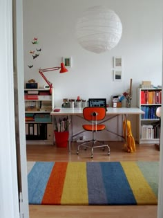 a room with a desk, chair and bookshelf