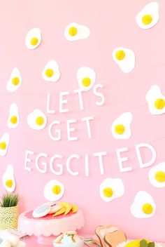 a pink table topped with eggs and cake