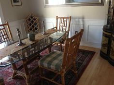 a dining room table with chairs and a rug on the floor in front of it