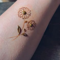 a woman's arm with flowers painted on it