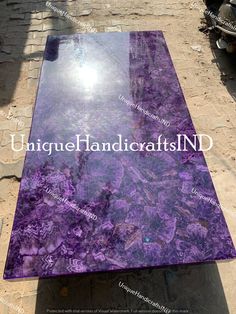 a large purple marble table sitting on top of a sidewalk