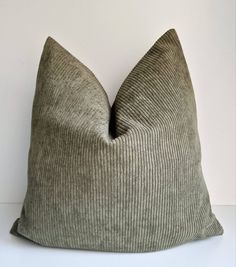 a gray pillow sitting on top of a white table