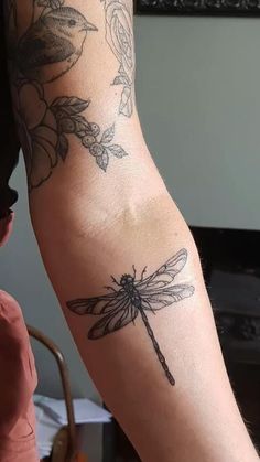 a woman with a dragonfly tattoo on her arm