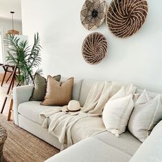 a living room filled with lots of furniture next to a wall mounted wicker baskets