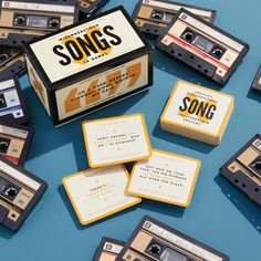 an assortment of old school cassettes are arranged on a blue surface with the words songs printed on them