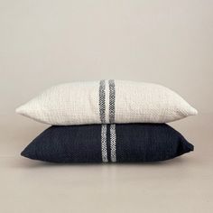 two black and white pillows stacked on top of each other