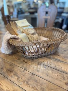 a wooden table topped with a basket filled with bread and other items on top of it