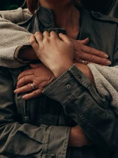 an older woman is holding the arm of her younger companion, who has both hands on her chest