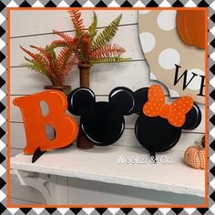 two mickey mouse ears are sitting on top of a mantle with the letter b in front of them