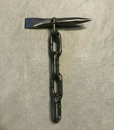 a pair of scissors that are attached to a chain on a white sheet with a black handle