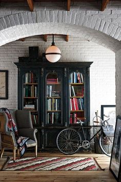 an old fashioned bookcase in the corner of a room filled with books and furniture