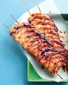 several skewers of food on a green tray