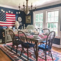 a dining room table with chairs and an american flag on the wall