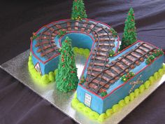 a train themed cake with trees on top