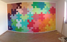 a large colorful puzzle piece mural on the wall in a room that is being renovated