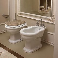 a white toilet sitting next to a bidet in a bathroom on top of a counter