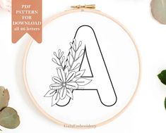 an embroidery pattern with the letter a and flowers on it, next to some succulent