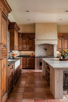 a large kitchen with wooden cabinets and tile flooring, along with an island in the middle