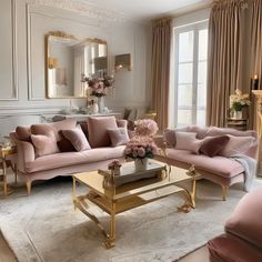 a living room filled with pink couches and pillows on top of a white rug