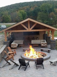 an outdoor fire pit with chairs around it