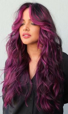 When discussing hairstyles ideas, the enchanting purple haze of magenta waves can't be overlooked. This style is a convergence of color and grace, with waves that flow like silk and a color that's as deep as twilight. It's a hairstyle that stands at the crossroads of fantasy and reality, perfect for those who carry a sense of mystique and a penchant for dreamy aesthetics. Plum Hair With Pink Highlights, Funky Dark Hair Color, Vivid Hair With Bangs, Purple Balayage With Money Piece, Vivid Color Highlights, Purple Pink And Black Hair, Purple Pink Balayage, Brown Hair With Fun Colors, Barbiecore Hair