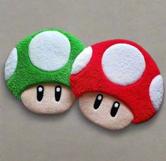 two small mushroom shaped magnets on top of each other's backs, one with eyes and the other with ears