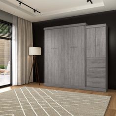 a room with black walls and wooden flooring has a large rug on the floor