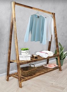 a clothes rack with clothing on it and a potted plant in front of it