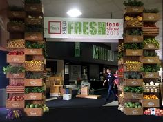 the fresh food show entrance is decorated with cardboard boxes and crates full of fruit, vegetables and veggies