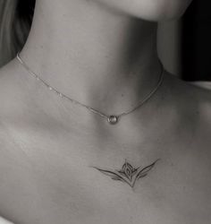 a black and white photo of a woman's chest with a lotus tattoo on it