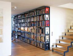 a bookshelf filled with lots of books next to stairs