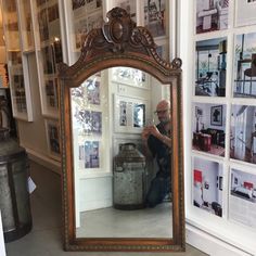 a man sitting in front of a large mirror