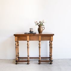 a vase with flowers on top of a wooden table