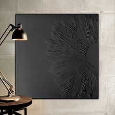 a wall mounted art piece on the side of a wall next to a table with a lamp