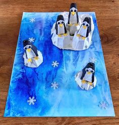 three penguins are on an iceberg with snowflakes