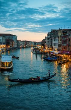 a gondola in the middle of a river with buildings on both sides at night