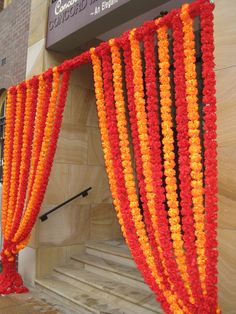 an orange and red drape hanging from the side of a building