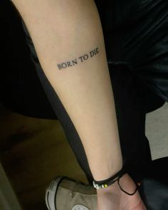 a woman's arm with the words born to die tattooed on her left forearm